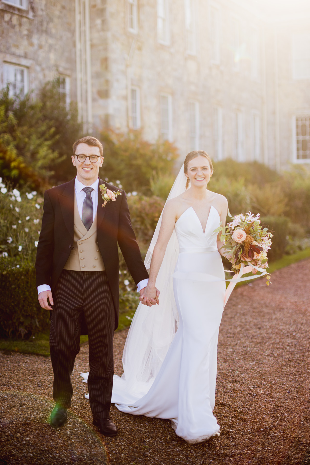 Gorgeous sunlight peeking over a wedding couple at Firle Place in sussex